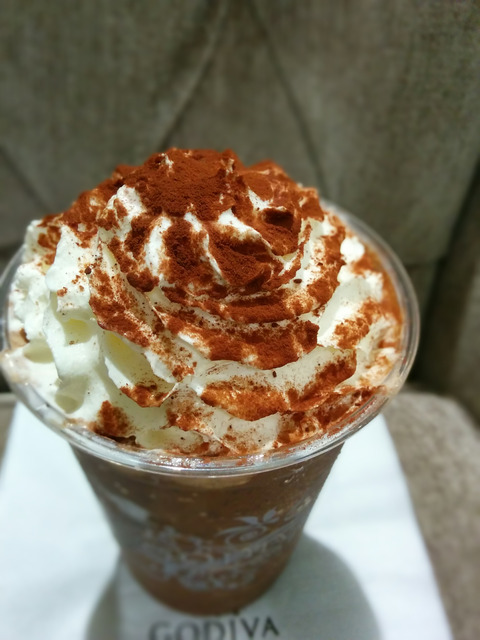 コーヒー色のフローズンドリンクでホイップクリームがたっぷり上に乗っており、ココアパウダーがかかっていて美味しそうです